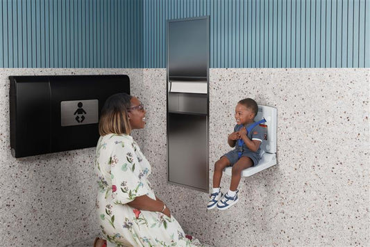 Woman sitting on a bench next to a child using a wall-mounted seat.