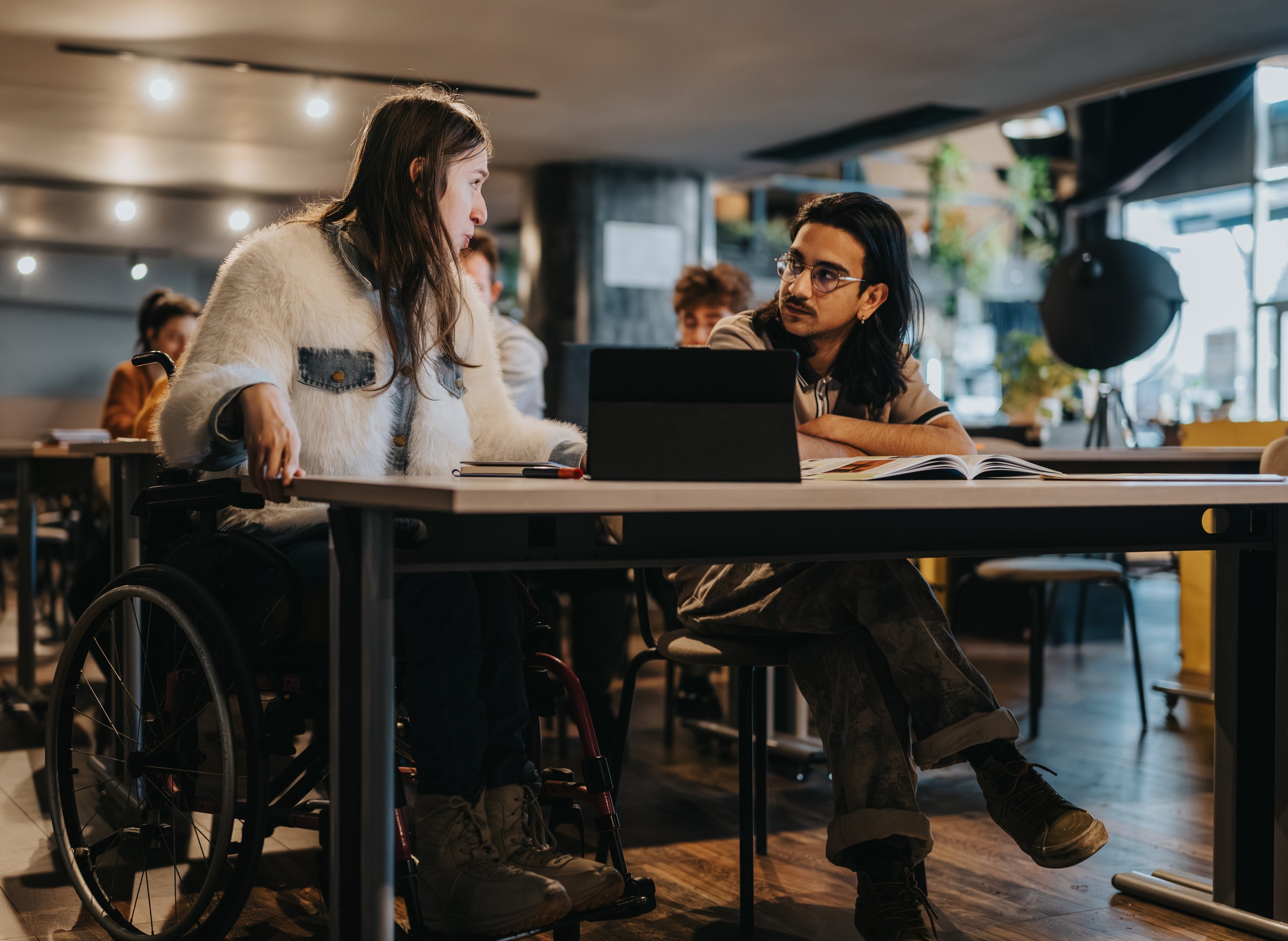 A woman in a wheelchair spending time at a coffee shop.
