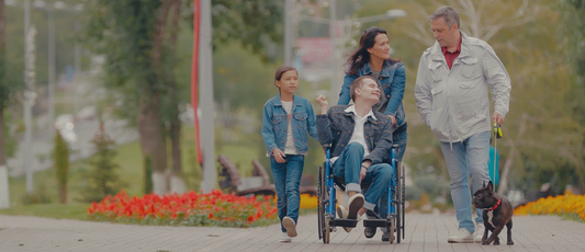 Family walking outside with their child in a wheelchair