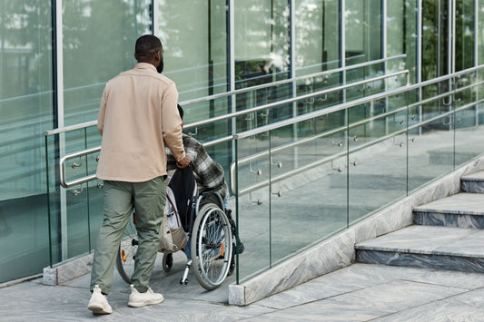 Man pushing a man in a wheelchair up a ramp