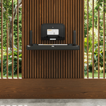 Black Element Baby Changing Station with Liner Dispenser on a wooden shelf against a wooden wall with greenery in the background