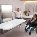Person in a wheelchair sitting near an adult changing table
