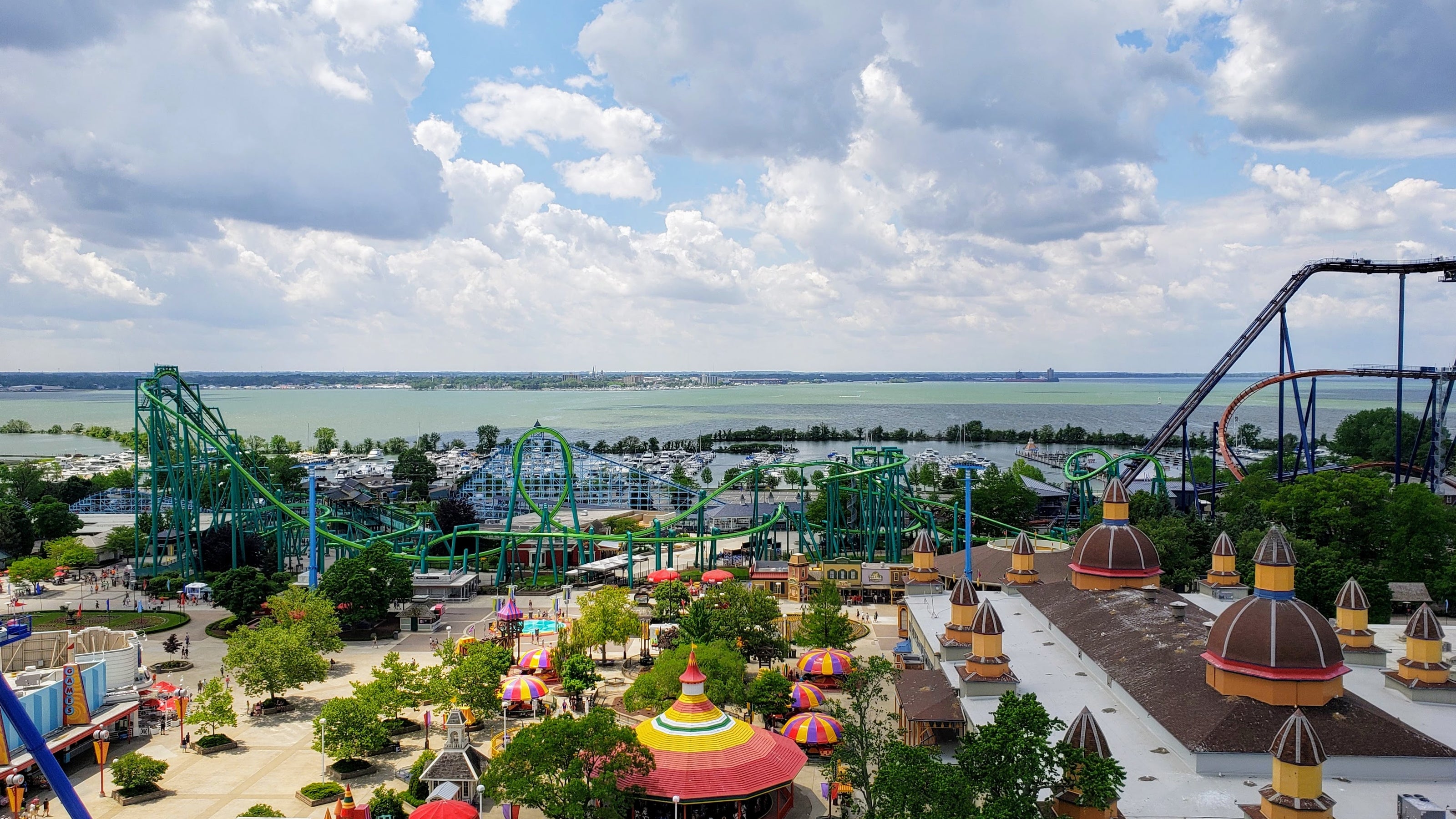 Amusement park with roller coasters and attractions under a cloudy sky.