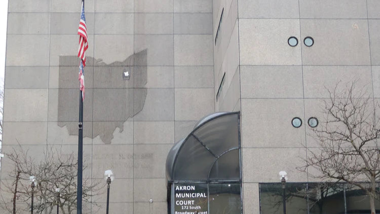 Building exterior with American flag and 'Akron Municipal Courthouse' sign.